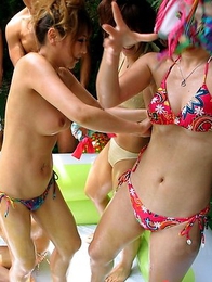 Asian teens wrestle by the pool