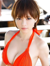 Japanese Yumiko Shaku  in orange bath suit takes a walk on the beach
