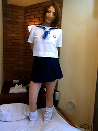 Reiko posing in her skimpy schoolgirl uniform before she strips down to suck a cock